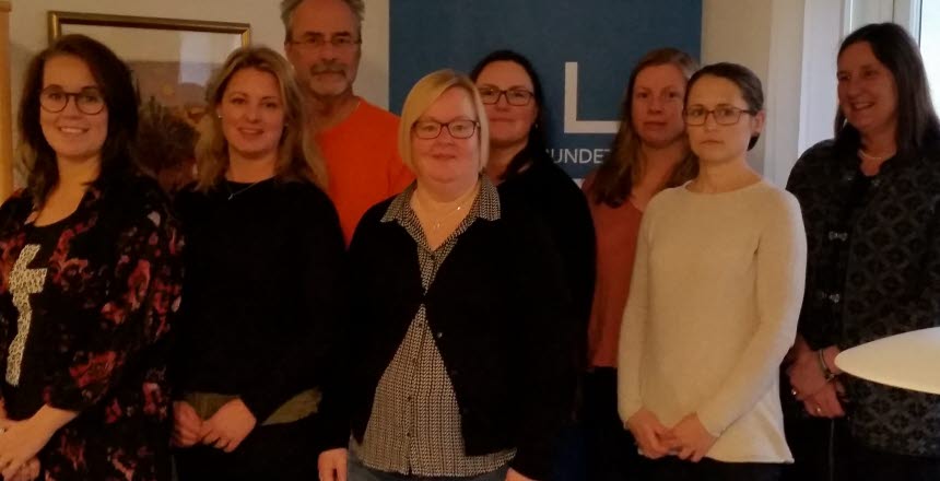 Åtta personer som står samlade, sju kvinnor och en man