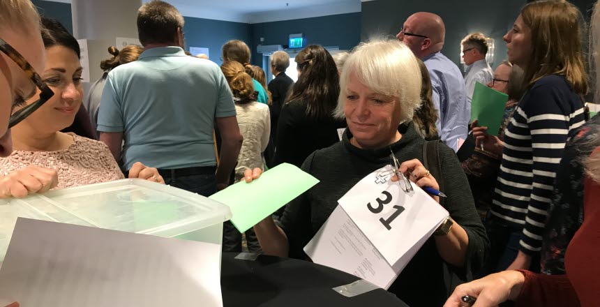 En kvinna lägger en röstsedel i en låda