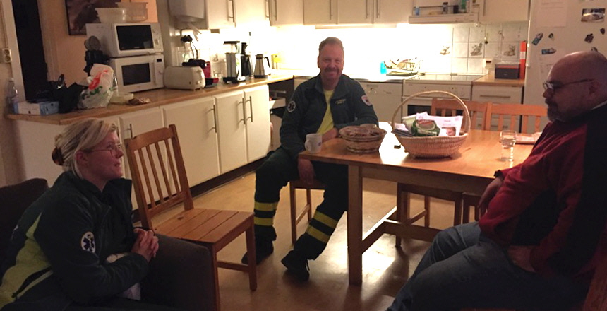Två medlemmar som jobbar inom ambulansen sitter i fikarummet tillsammans med en förtroendevald och pratar