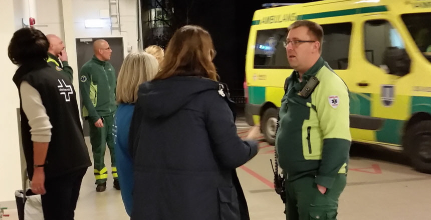 Flera förtroendevalda diskuterar stående i ambulanshallen på Danderyds sjukhus