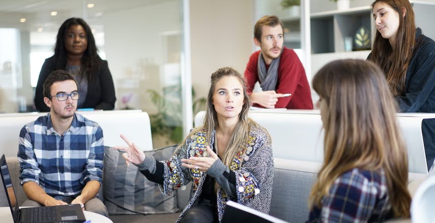 En grupp personer som sitter i en soffa och diskuterar