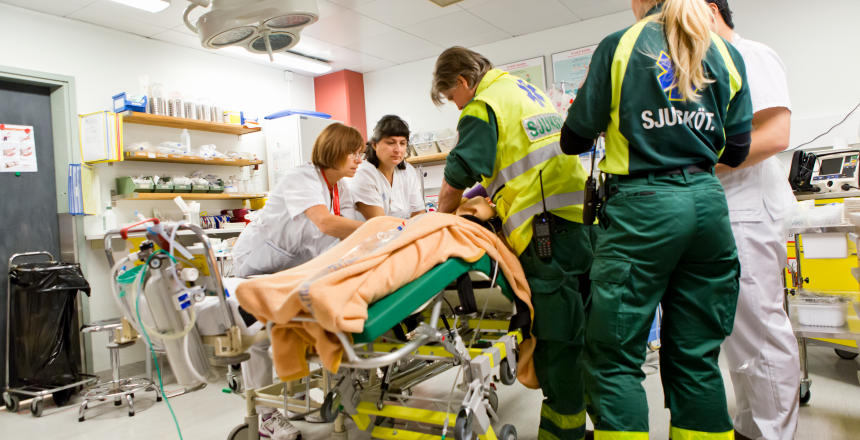 Ambulans och akutsjuksköterskor arbetar med patient i ett akutrum.