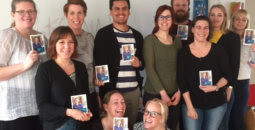 Gruppbild på deltagarna med handboken för dig som är förtroendevald hållande framför sig