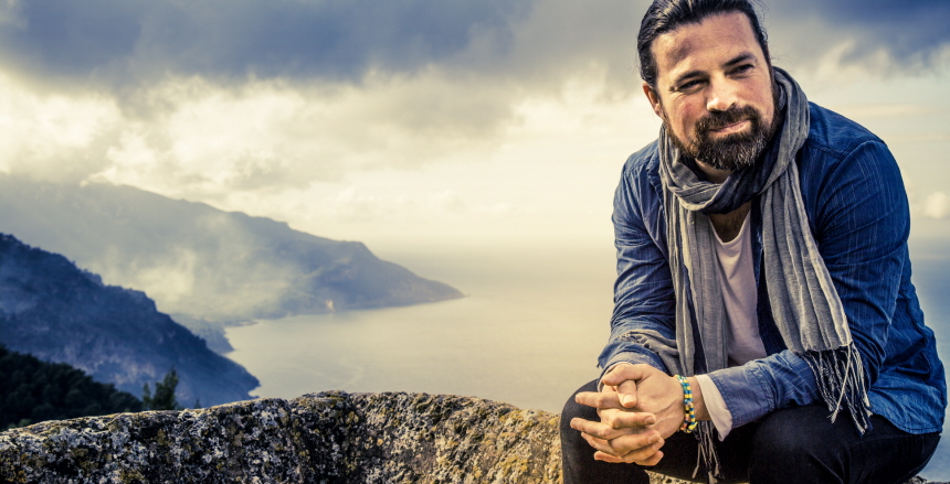 Daniel Mendoza sittande på en bergstopp med händerna i knäet