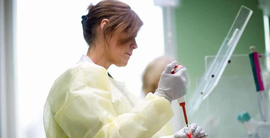 Biomedicinsk analytiker som arbetar med ett prov på Karolinska sjukhuset.