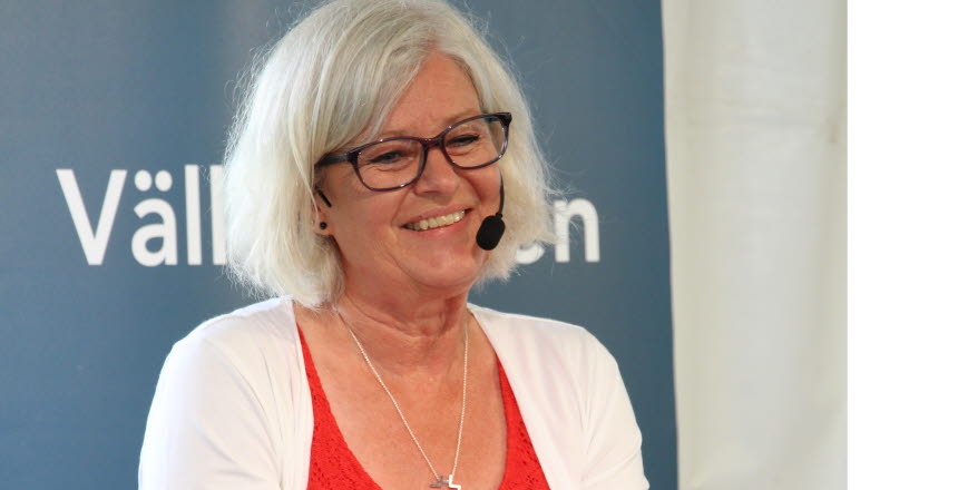 Kvinna ler med mikrofon. Det är Ann Johansson, Vårdförbundet.
