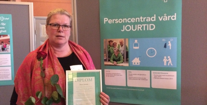 Annika Serrander klädd i en röd sjal med ett diplom och en röd ros i handen.