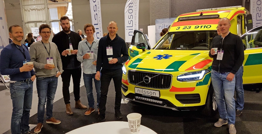 Ett antal personer står bredvid en ambulans